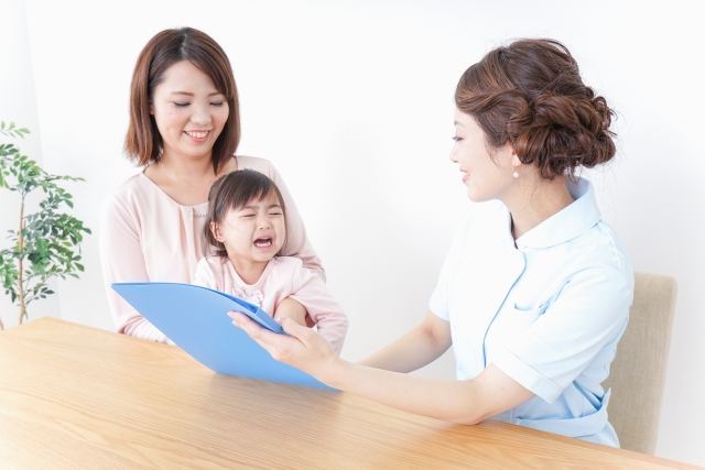 こどもの検診での保健師とママ、泣く女の子