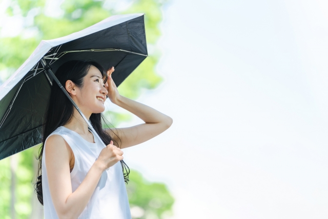 日傘で太陽を遮る女性