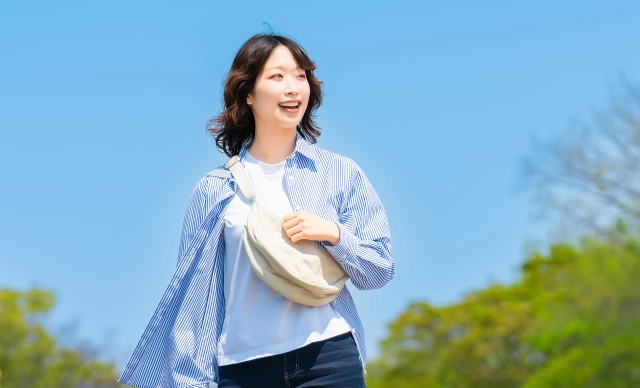 青空の下歩く女性